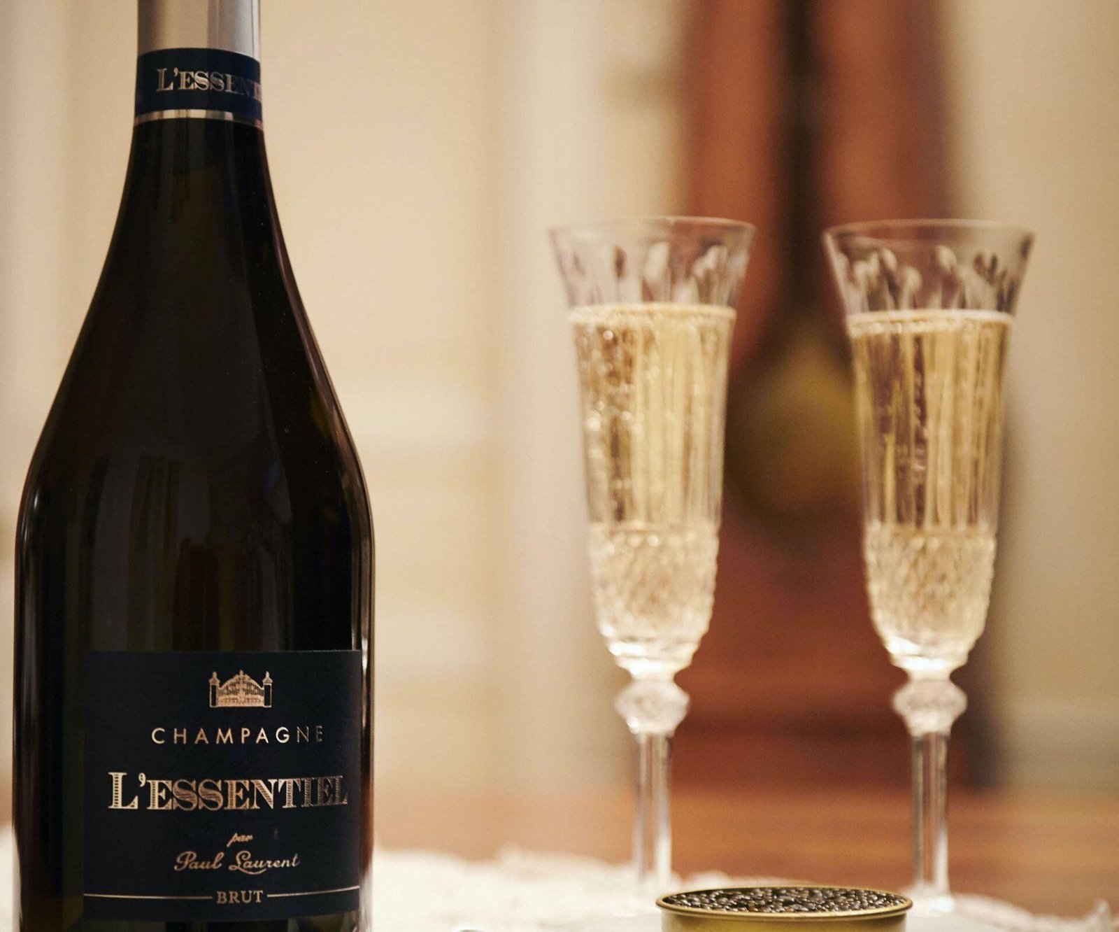 Bottle of Cuvée L'Essentiel next to two crystal champagne glasses
