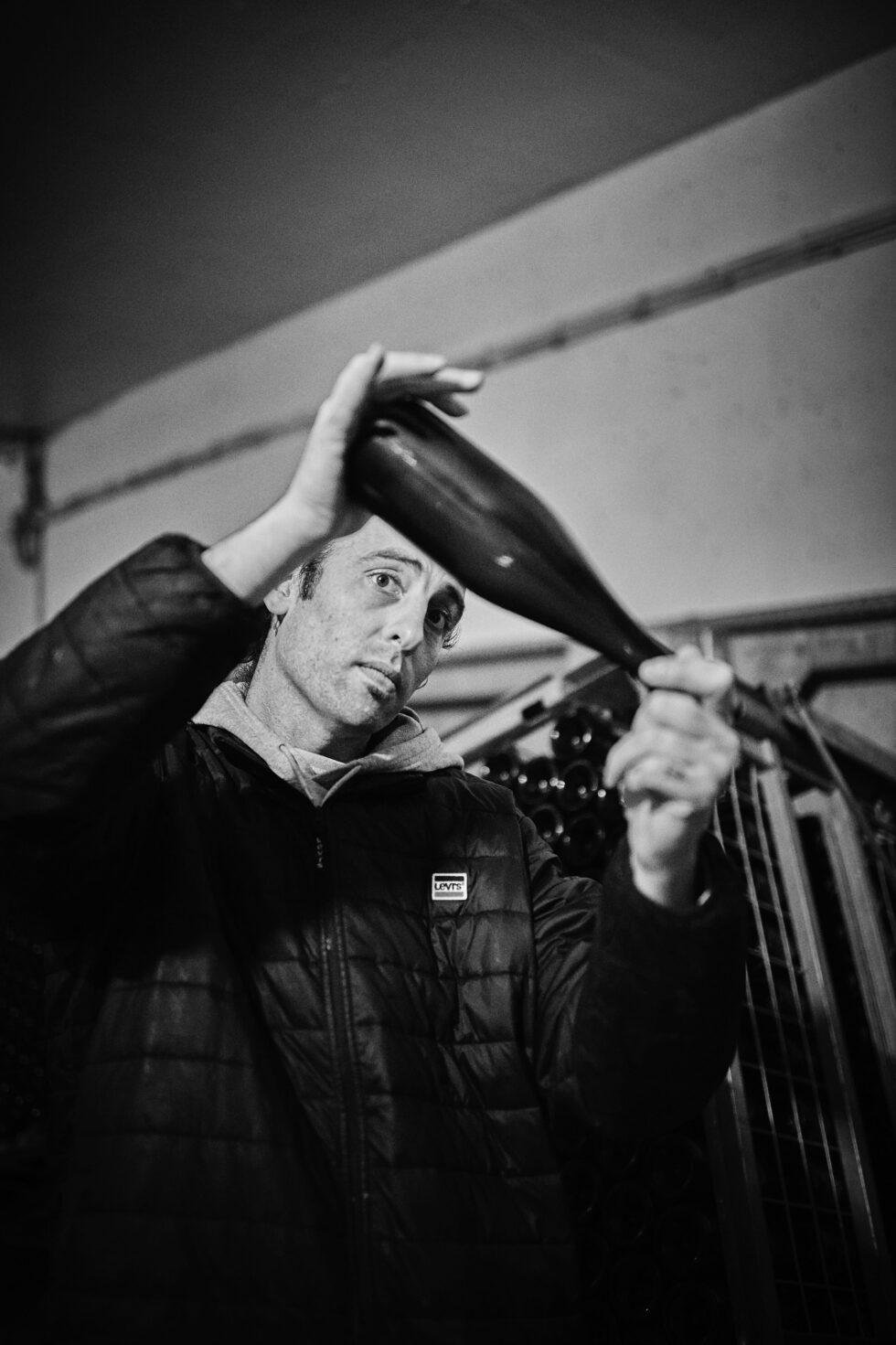 Cellar worker holding up a champagne bottle to check it against the light